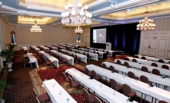 a large , empty conference room with rows of tables and chairs set up for an event at The Saint Paul Hotel