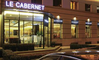 A spacious building with a front entrance featuring windows and doors leading to an outdoor restaurant or café at Novotel Beijing Peace
