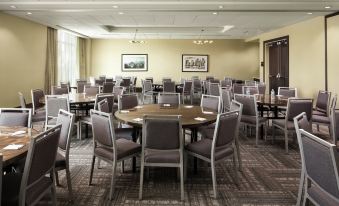 a large dining room with multiple tables and chairs arranged for a group of people at Hampton Inn & Suites Teaneck Glenpointe