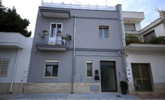 a two - story house with a gray exterior and a black door on the left side at La Piazzetta