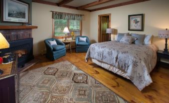 a cozy bedroom with hardwood floors , a large bed , and a rug on the hardwood floor at Snowvillage Inn
