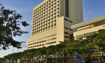 a tall , beige - colored hotel building with a sign in chinese characters , situated on a busy street at Pearl View Hotel Prai, Penang