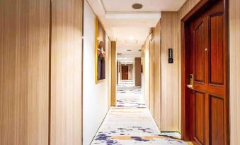 There is a long hallway with doors on both sides and a carpeted floor at the end in a modern setting at Towns Well Motel