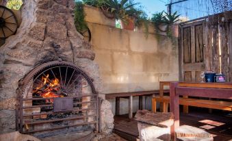an outdoor fireplace with a fire pit , surrounded by chairs and tables , in a courtyard setting at Prince of Wales Hotel Gulgong