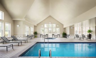 a large swimming pool with a hot tub and lounge chairs in a spacious room at Residence Inn Philadelphia Langhorne
