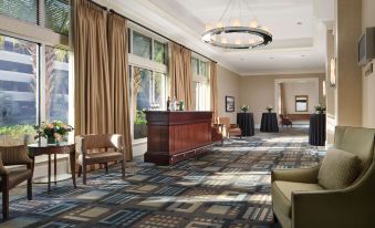 a large , well - lit hotel lobby with multiple couches , chairs , and tables set up for meetings or events at Hilton Myrtle Beach Resort