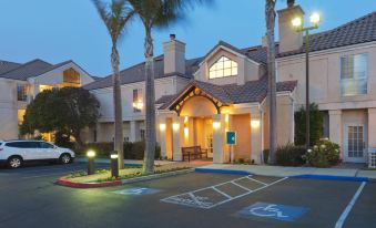 a building with palm trees and lights is shown in front of a parking lot at Sonesta ES Suites San Francisco Airport San Bruno