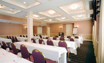 a large conference room with multiple rows of chairs arranged in a semicircle , and a podium at the front of the room at Carleton of Oak Park