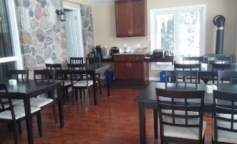 a dining room with a wooden floor and chairs arranged in various positions , creating an inviting atmosphere at Peninsula Motel