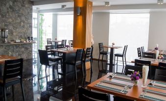 a dining room with several tables and chairs , some of which are occupied by people at Slive Hotel