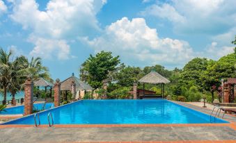 a large swimming pool surrounded by a wooden deck , with several lounge chairs and umbrellas placed around it at Sea Horizon Resort