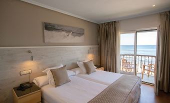 a large bed with white linens and a brown headboard is in a room with a sliding glass door leading to a balcony at Hotel Don Pepe