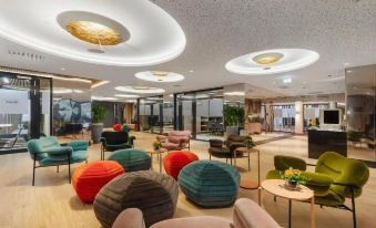 a modern and stylish lobby area with various seating options , including bean bag chairs , coffee tables , and potted plants at Hotel Alexandra Loen