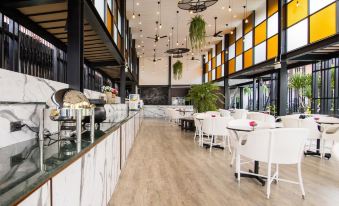 a modern restaurant with a long dining table , chairs , and various food items on display at Blue Lagoon Hotel