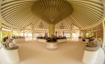 a large , circular room with a domed ceiling and tables set for dining in an open area at Hondaafushi Island Resort