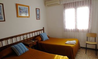 a hotel room with two beds , one on the left and one on the right side of the room at Hostal Roca