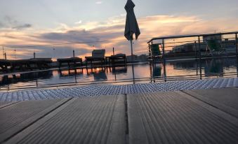 a serene scene of a swimming pool at sunset , with the sun setting in the background at Hotel Empire Albania