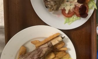two plates of food on a dining table , one with meat and the other with vegetables at Hillview Motel