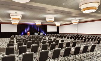 a large conference room with rows of chairs arranged in a semicircle , ready for an event at Hilton Garden Inn Troy