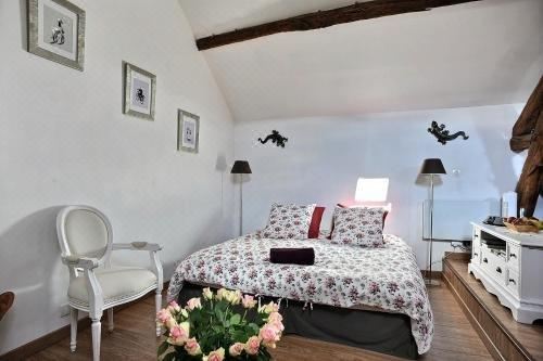 a cozy bedroom with a white bed , black chairs , and a potted plant on the floor at Le 5