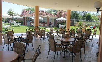 an outdoor dining area with several tables and chairs , providing a pleasant atmosphere for guests at Pegasus Hotel