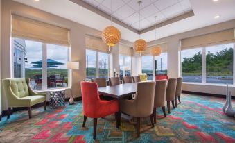 a dining room with a large dining table surrounded by chairs , and a colorful carpet covering the floor at Hilton Garden Inn Bristol