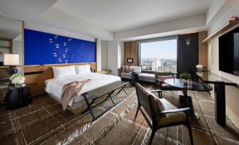 The room is furnished with large windows, a bed, and a desk in the middle, resembling an oriental style at Hyatt Centric Kanazawa