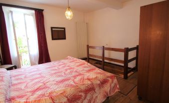 a bedroom with a bed , a dresser , and a window with a view of trees at Nicol