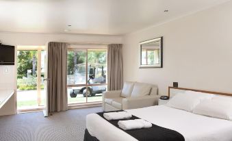 a bedroom with a large bed , couch , and sliding glass doors leading to an outdoor area at Murray Downs Resort