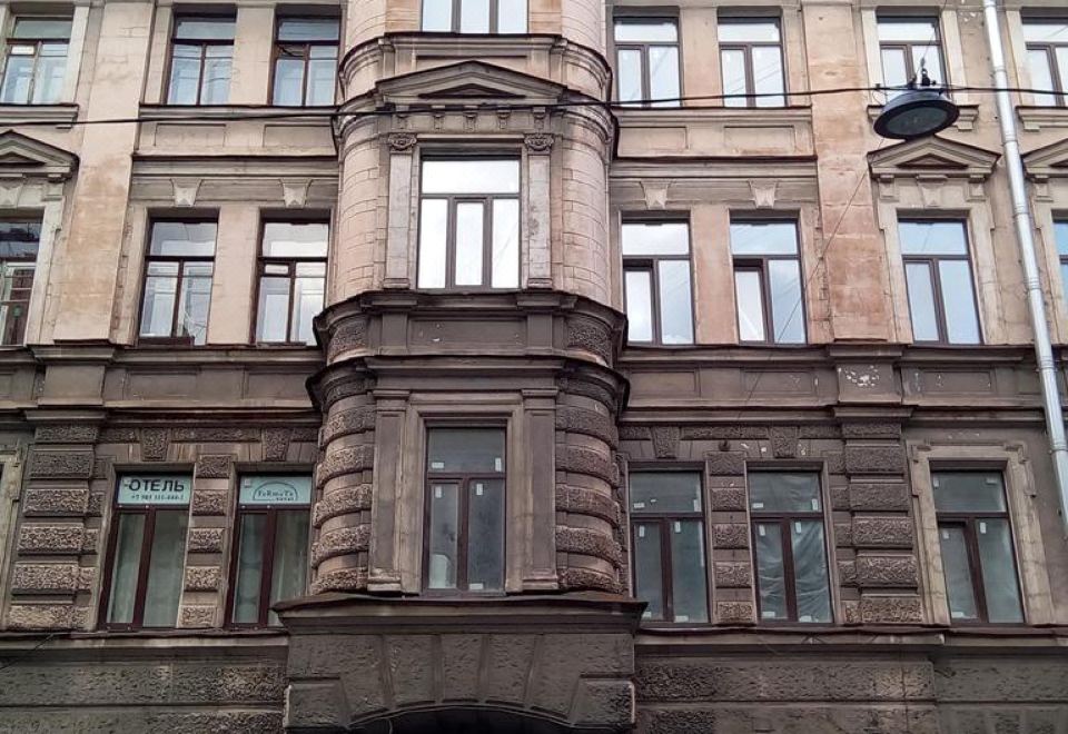 a large , old brick building with a wrap around porch and several windows on the second floor at Fabrika