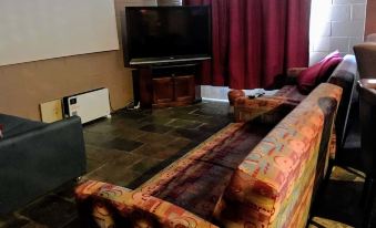 a living room with a large flat - screen tv mounted on the wall , along with a couch and chairs at Cottonwood Lodge