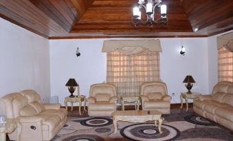 a spacious living room with wooden ceiling , beige furniture , and a chandelier hanging from the ceiling at White Horse Inn