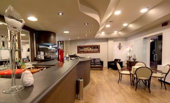 a modern kitchen with wooden flooring and a bar area , featuring a sink , cabinets , and stools at Hotel Park