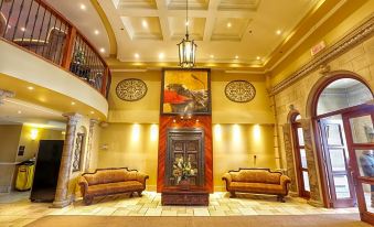 a large , elegant hotel lobby with multiple couches and chairs arranged around a central fireplace at Hotel Brossard