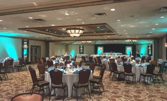 a large banquet hall with multiple round tables and chairs , set up for a formal event at SureStay Plus Hotel by Best Western Lehigh Valley