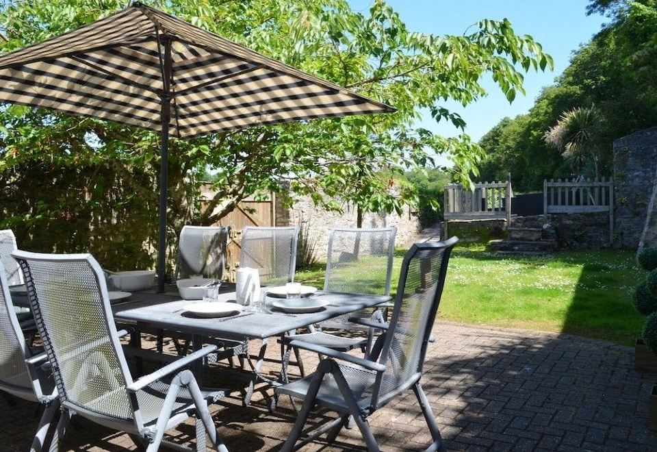 a backyard with a patio set on a patio , surrounded by trees and a gazebo at Lakeside