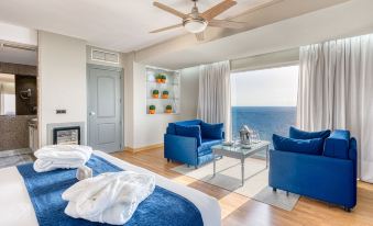 a bedroom with a bed , chairs , and a television is shown with a view of the ocean at Playadulce