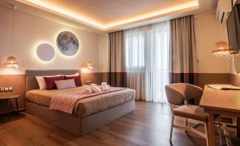 a spacious bedroom with a large bed , a chair , and a lamp on the nightstand at Asteris Village