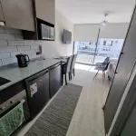 In front of Hospital U. de Chile with parking lot.