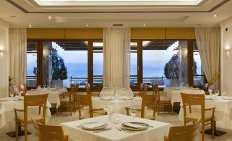 a dining room with tables and chairs arranged for a group of people to enjoy a meal at Negroponte Resort Eretria