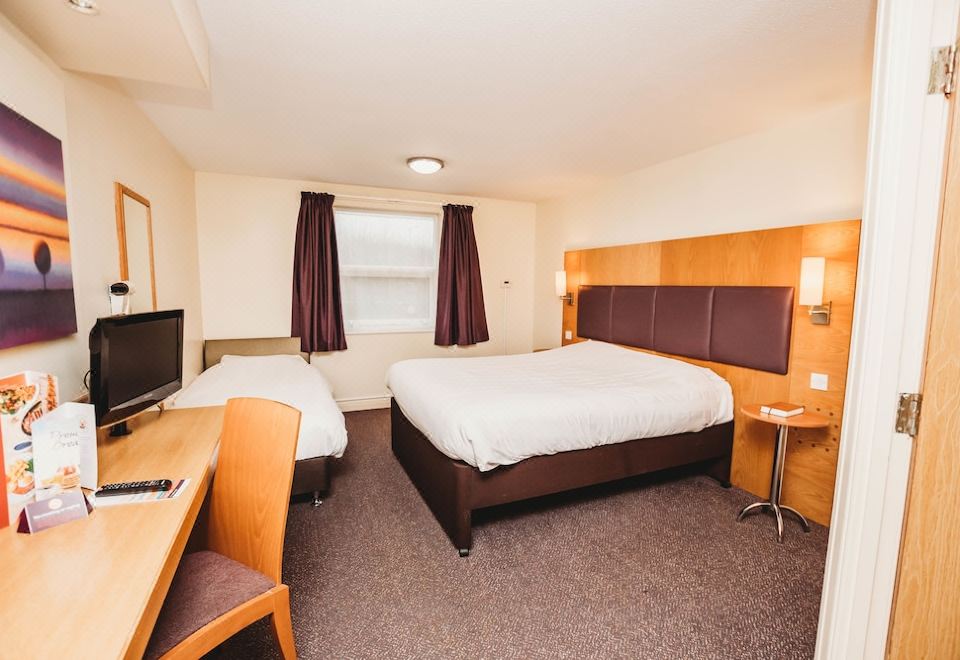 a hotel room with three beds , two of which are twin beds and one is a double bed at Purple Roomz Preston South