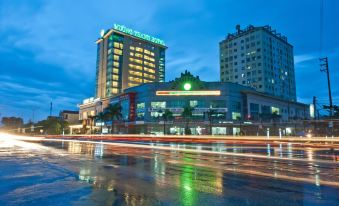 a large hotel building in the city , with lights from cars and buildings lit up at night at Muong Thanh Dien Chau Hotel