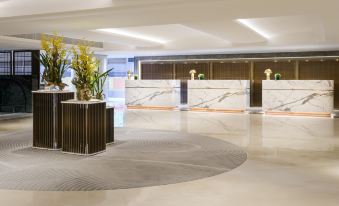 The hotel features an elegant reception area with a large lobby adorned with marble floors and wood paneling at The Royal Pacific Hotel and Towers