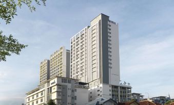 a tall , white building with a gray roof and balconies is surrounded by trees on a sunny day at Best Western I-City Shah Alam