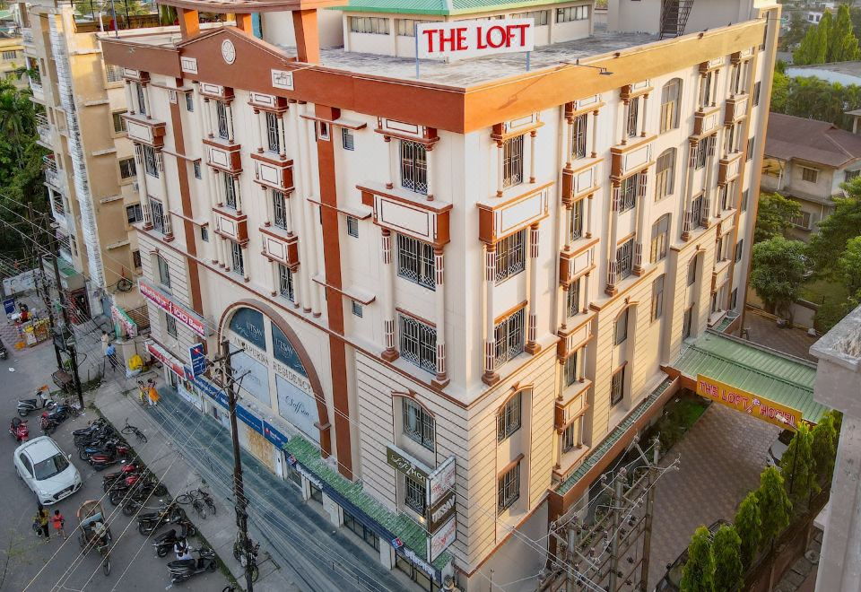 "a large building with a sign that reads "" the loft "" is surrounded by other buildings and streets" at The Loft Hotel, Siliguri