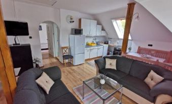 The living room is an area with large windows, a couch, and a coffee table in the middle at Landhaus Forrás