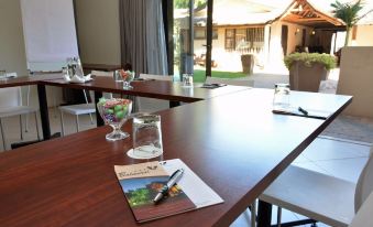 a conference room with wooden tables , chairs , and a whiteboard , set up for a meeting or presentation at Balmoral Lodge