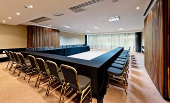 a large conference room with a long table and numerous chairs arranged for a meeting at Majestic Palace Hotel