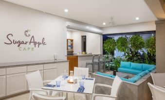 a modern kitchen with white cabinets , a dining table with chairs , and a large window at Beach View Hotel