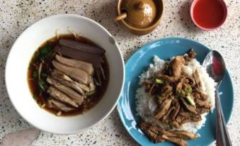 a dining table with two plates of food , one containing rice and meat , and the other with meat and vegetables at Phutawan Kan Resort